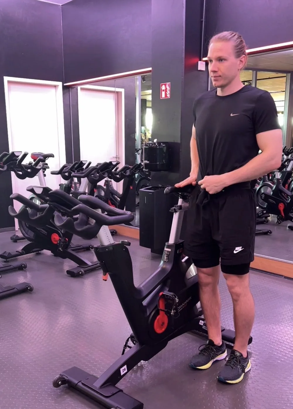 Valeriy steht neben dem Bike, die Hand auf dem Sattel: Sattel auf Höhe des Beckenknochens